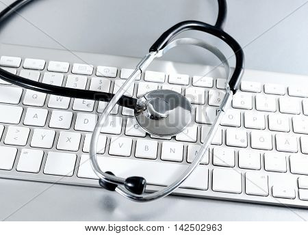 Computer keyboard with medical stethoscope, it-support scene.