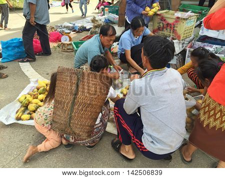 CHIANG RAI THAILAND - AUGUST 9 : horizontal photo of unidentified people buying mangoes in a market at the Thai-Laos frontier on August 9 2016 in Chiang rai Thailand. This is one of travel attraction in Chiang Rai.