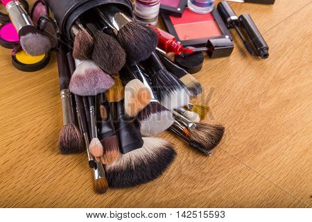 Paints, brushes and other makeup tools on the table.