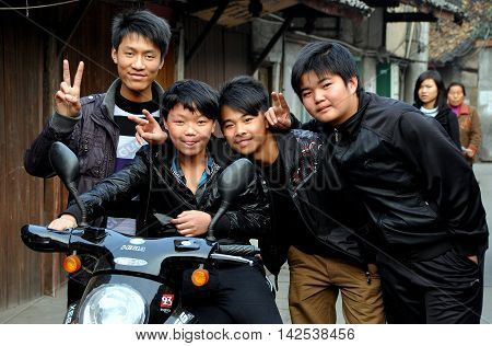 Pengzhou China - November 25 2011: Four young high school students on their way home after class on Hua Lu (Old Street)