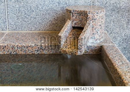 Close up section of onsen marble bathtub and marble faucet Japanese style bath