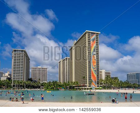 HONOLULU, USA - AUG 7: Sun lovers on Waikiki beach at the Hawaiian Hilton on August 7, 2016 in Honolulu, Usa. Waikiki beach is neighborhood of Honolulu, best known for white sand and surfing.