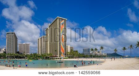 HONOLULU, USA - AUG 7: Sun lovers on Waikiki beach at the Hawaiian Hilton on August 7, 2016 in Honolulu, Usa. Waikiki beach is neighborhood of Honolulu, best known for white sand and surfing.