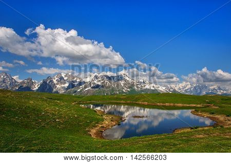 Reflection of snow-capped peaks of the main Caucasian ridge into the lake koruldi. Georgia, Svaneti