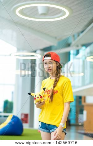BANGKOK THAILAND – August 142016: Trainer girl playing pokemon pokemon ball Lighting with sun flare