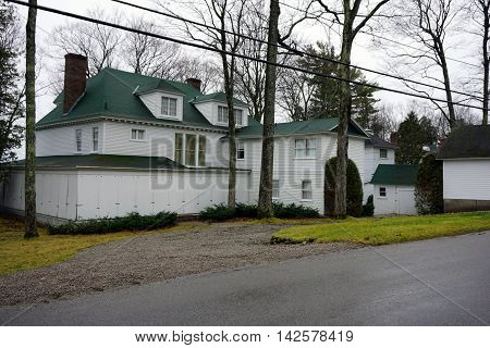WEQUETONSING, MICHIGAN / UNITED STATES - DECEMBER 23, 2015: A large white home, on Beach Road in Wequetonsing, is boarded up for the winter weather.
