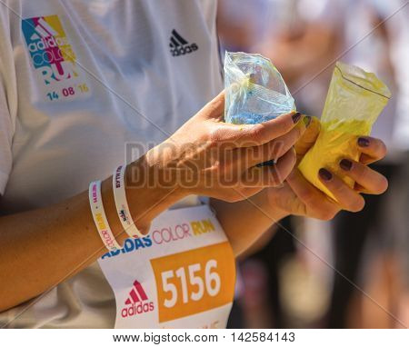 Ukraine, Kyiv - 08/14/2016.  Kyiv color run. Run 5 km from the colors of Holi. woman holding bags colors of Holi.