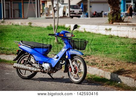 SITIA, CRETE, GREECE - JUNE 2016: Blue motorcycle at road of Sitia town on Crete island