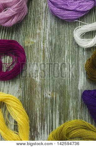 Bright wool thread for embroidery and needlework. Sewing threads for embroidery. Mouline floss on rustic wooden table