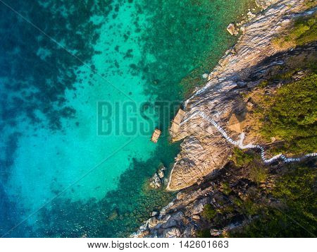 rocky coast with steps down to the turquoise water from the height of bird, Koh Phangan, Thailand