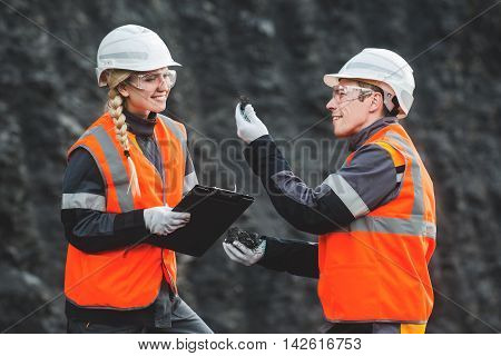 Two speacialists examining coal at an open pit