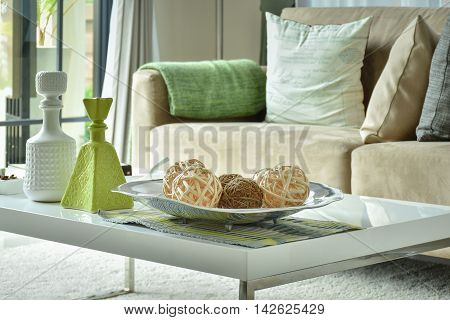 Ratten balls and vases on white top table with light brown sofa