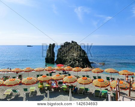 Monterosso, Italy - September 09, 2015: People on the coastline of Monterosso in Italy. Monterosso is one of five famous coastline villages in the Cinque Terre National Park.