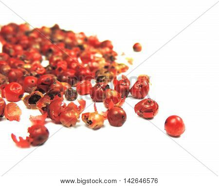 Red peppercorns with selective focus, isolated on white background.