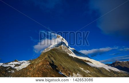Snow capped mountains. Matterhorn mount in the clouds at early morning. view of the north- eastern ridge . Trek near Matterhorn mount.