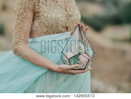 pregnant woman holding a glass box with roses