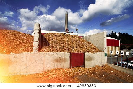 Bio Power Plant With Storage Of Wooden Fuel Against Blue Sky
