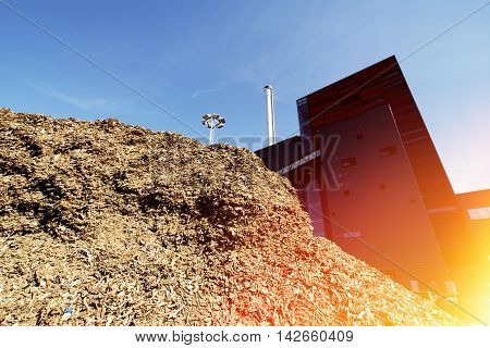 Bio Power Plant With Storage Of Wooden Fuel Against Blue Sky
