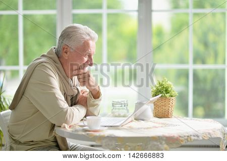 Portrait of a senior man using laptop