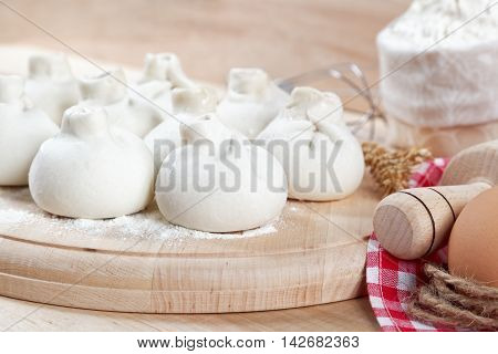 Baking ingredients for cooking manti dumplings on a wooden board.