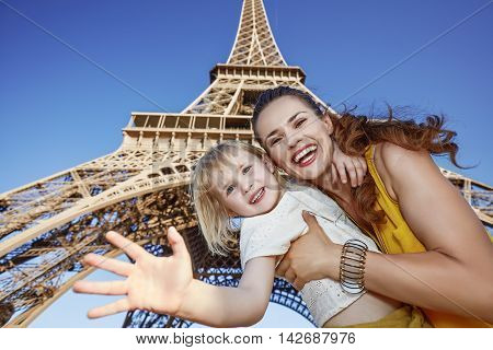 Happy Mother And Daughter Handwaving Against Eiffel Tower