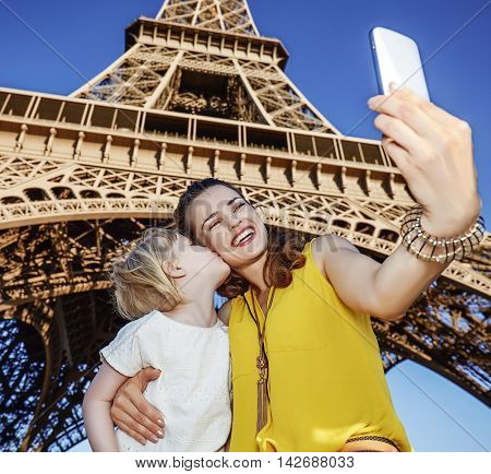 Mother And Daughter Tourists Taking Selfie Near Eiffel Tower