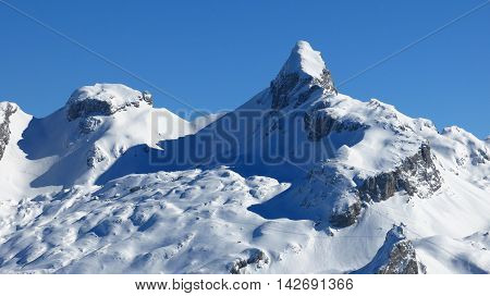 Snow covered mountains in the Swiss Alps. View from Mt Klingenstock. Peak of Mt Chronenstock.