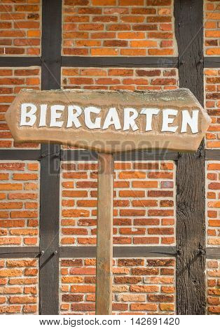 Beer garden sign in front of a traditional german half-timbered wall