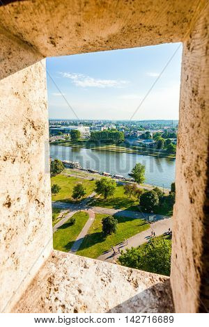 View of modern part of Krakow and the river Visla through the opening in wall from Wawel castle Watchtower, Poland.