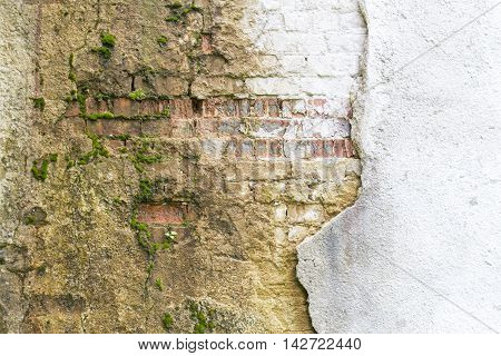 Broken vintage bricklaying wall fragment from old red clay bricks and damaged plaster frame background