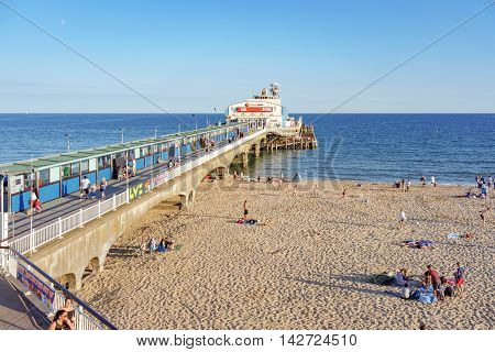 Bournemouth/UK. 14th August 2016. Day trippers enjoy the warm sunshine of Bournemouth Pier and beach at dusk.