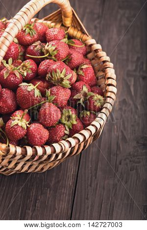 Basket of strawberries on rustic wooden table