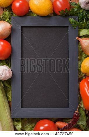 Black menu blackboard with various vegetables around