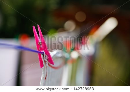 Clothespins holding laundry on the drying line drying clothes outside on fresh air wind and sun. Housework family life household natural living and lifestyle concept.