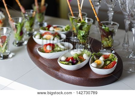 Boiled quail eggs, tomatoes, lettuce. All laid out on beautiful white plates