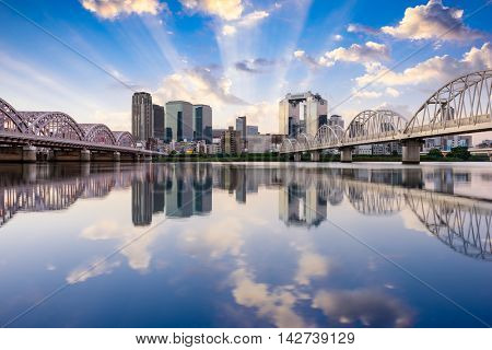 Osaka, Japan downtown skyline on the Yodogawa River at dawn.