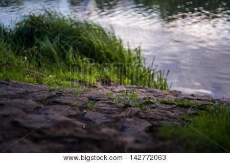 sloping road from a stone blocks to the quiet river
