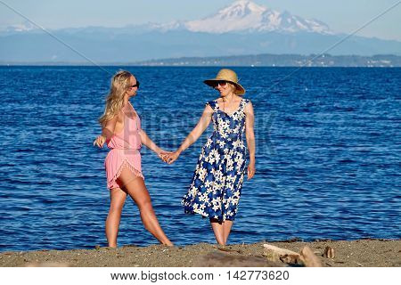 Two women mother and daughter on beach. Centennial Beach at Boundary Bay Regional Park Tsawwassen British Columbia Canada.
