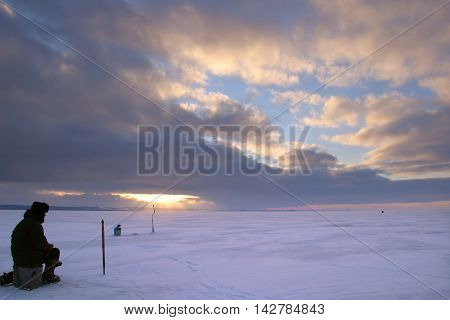 Fisherman On The River Covered With Ice