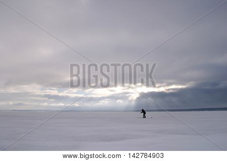 Fisherman On The River Covered With Ice