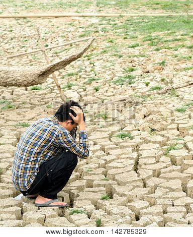 The farmer sitting on mud crack in dry season