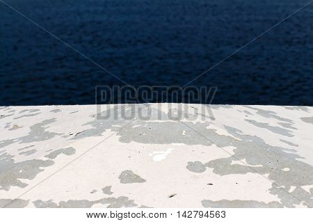 Stone colored old and cracked paint. The back water. Foreground and background are blurred.