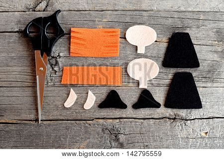 Felt witch patterns and scissors on old wooden background. How to sew a Halloween witch doll. Halloween hand crafts project. Easy tutorial for children and beginners. Step. Top view