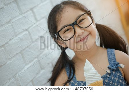 Happy Asian girl enjoy eating soft ice-cream