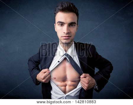 Businessman tearing off his shirt and showing mucular body concept on background