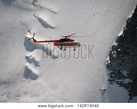 Helicopter flying in the background of snowy mountains