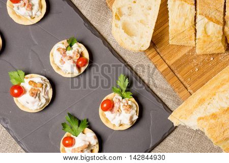 canapes appetizer with creamy Chicken salad served on a slate plate