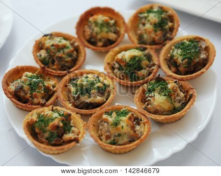 tartlets with chicken salad and herbs on white plate