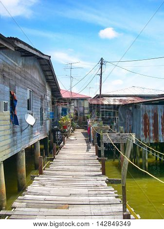 Fishing village in Brunei with wooden bridge or gangplank.