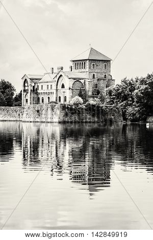 Castle in Tata Hungary. Travel destination. Architectural theme. Black and white photo. Beautiful place. Fortress is reflected in the lake. Vertical composition.